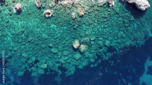 4K Aerial Drone Footage of Crystal Clear Sea Water with Rocks on the Seabed and Gentle Waves