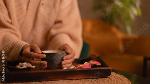 Bild auf Leinwand Closeup hand of woman client in Relaxing spa scene with tea ritual in cozy setti