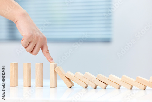 Fotografia Male Hand Blocking Falling Dominoes Chain Reaction Business Concept