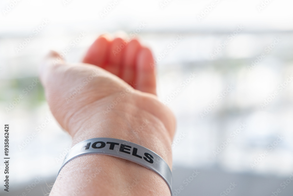 Obraz premium female hand adult beach vacation, wristband hotel resort identifier bracelet on beach, all inclusive vacation shared memories, travel summer holiday, identifier for resort access, security, or payment