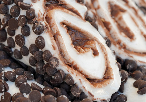 Macro shot of a gourmet Turkish delight roll filled with cream and chocolate, covered with dark chocolate chips