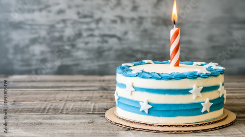 White and blue birthday cake with single orange striped candle and star decorations on rustic wooden table, simple celebration, festive touch, minimal style.
