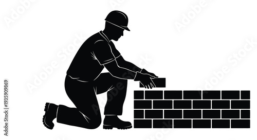 A construction worker kneeling and carefully placing a brick on a partially built wall depicted as a silhouette