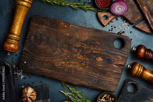 Kitchen background for menu or banner design. Kitchen cutting board, spices, vegetables and kitchen utensils. Top view. Free space for text.