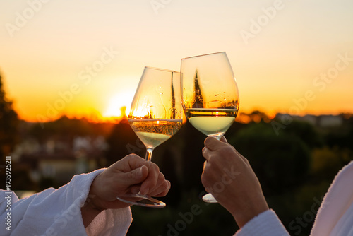 Fotografi Couple toasts white wine sunset rooftop hotel bathrobe, romantic aperitif luxury