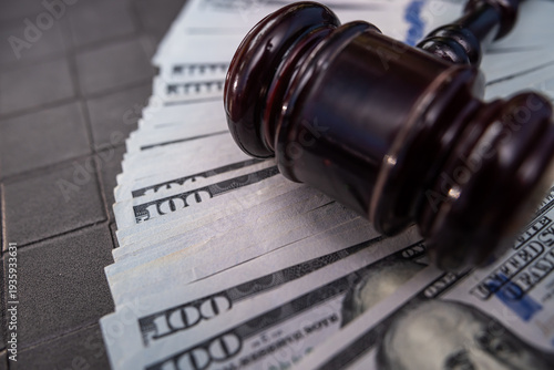 Wooden Judge Gavel Over US Dollar Banknotes Symbolizing Financial Law And Penalties