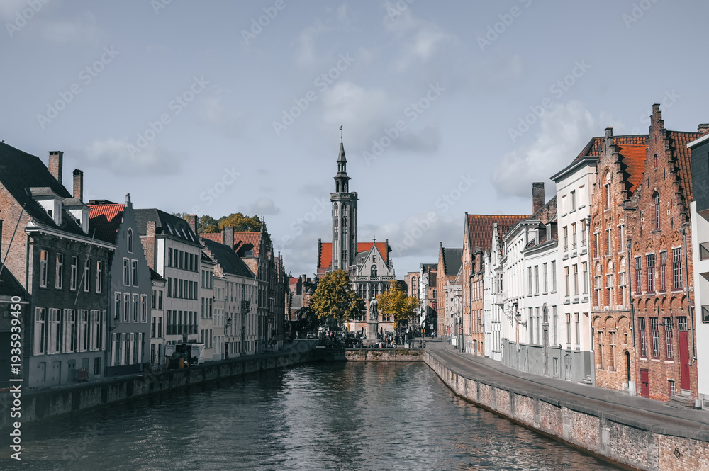 Naklejka premium Scenic canals and historic medieval architecture in Bruges, Belgium, featuring traditional Flemish buildings along the water in the iconic European city.