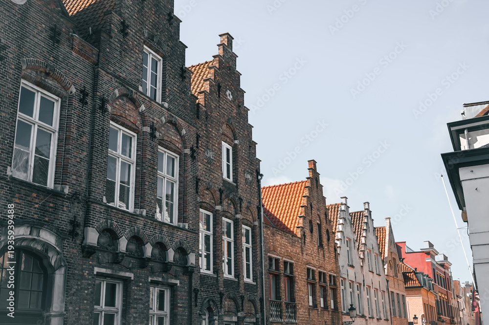 Naklejka premium Scenic canals and historic medieval architecture in Bruges, Belgium, featuring traditional Flemish buildings along the water in the iconic European city.
