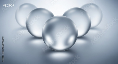 Four transparent glass balls on reflective surface with one in front on transparent background