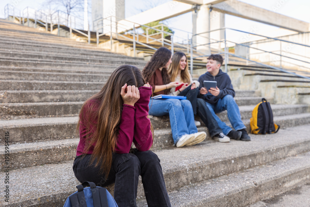 Fototapeta premium Sad teenage girl feeling excluded from her schoolmates