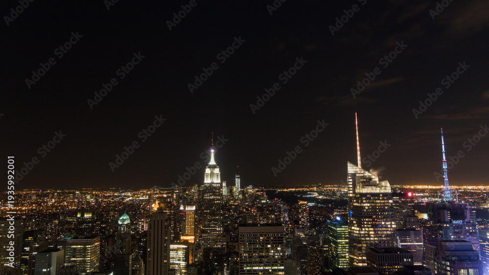 Fototapeta premium Empire State Building Illuminated Over Midtown Manhattan