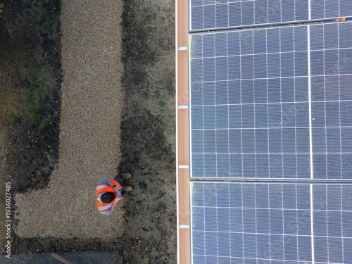 Vue de dessus d’une toiture solaire avec homme de chantier – installation photovoltaïque et énergie renouvelable