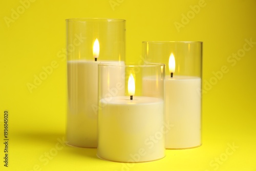 Fotografie Beautiful LED candles on yellow background, closeup