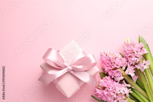 Beautiful hyacinth flowers and gift box on pink background, flat lay. Space for text