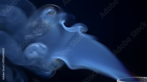 Plumes of wispy blue smoke rising against a dark background