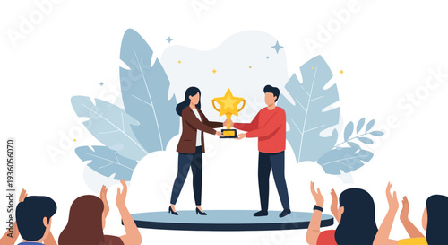 Man and woman exchanging golden trophy on stage surrounded by applauding audience