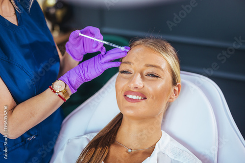 Smiling Woman Receiving Cosmetic Injection At Aesthetic Clinic During Facial Beauty Treatment And Consultation
