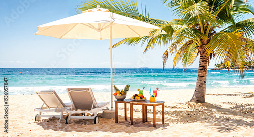 Tropical beach with palm tree shading two lounge chairs under umbrella, side table with fresh fruit platters and colorful cocktails.