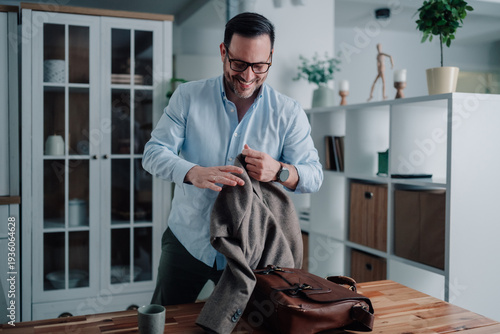 Valokuva Professional man preparing for work at home, smiling while getting ready for a s
