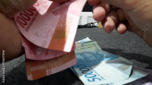 The act of counting cash represents common financial activities such as salary calculation, budgeting, savings, payments, profit, and expense management