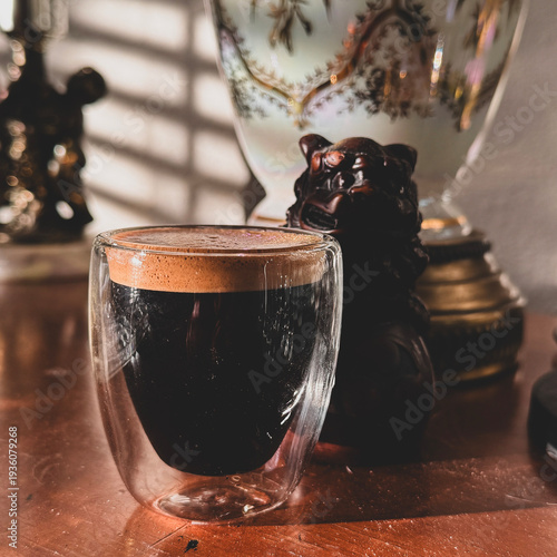 Fresh Espresso in Double-Wall Glass with Golden Crema on Rustic Wooden Table in Warm Morning Light