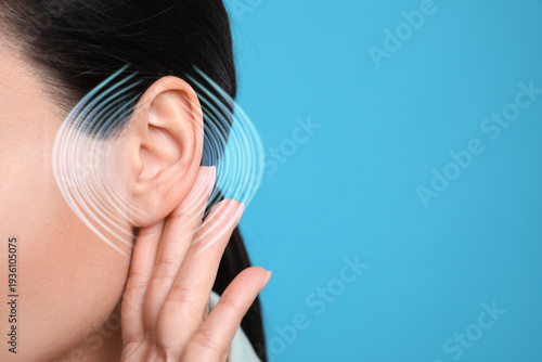 Hearing health. Woman with audio waves around her ear on blue background, closeup