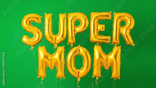 Large gold foil balloons spell out Super Mom floating against a solid green backdrop.