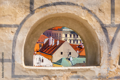 Fényképezés Summer cityscape - view from above through the loophole of the Cesky Krumlov Cas