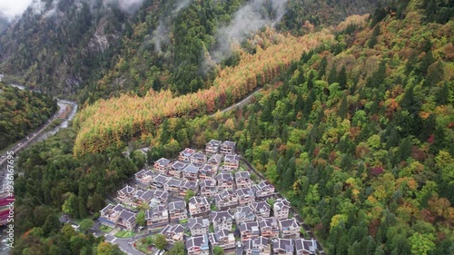 Drone view of Yangrong Hade, or Yangrong Village, well-preserved Jiarong Tibetan village in Aba, Sichuan, China. Colorful autumn forest in rainy day. 4k real time footage b roll shot travel concept