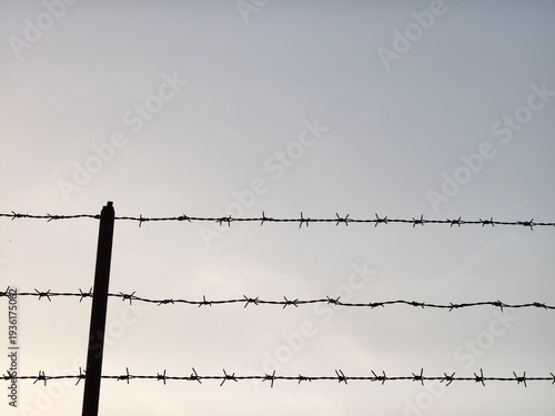 Barbed wire with blue sky as the background.