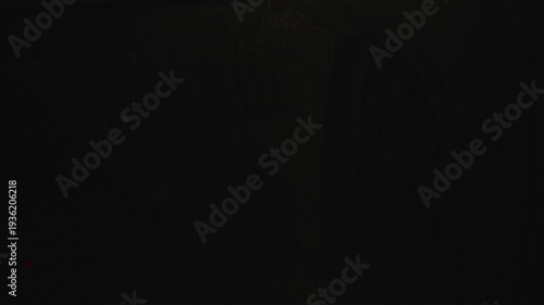 Moisture and streaks on car window while passing through tunnel, blurred lights sliding across glass during night drive inside moving vehicle