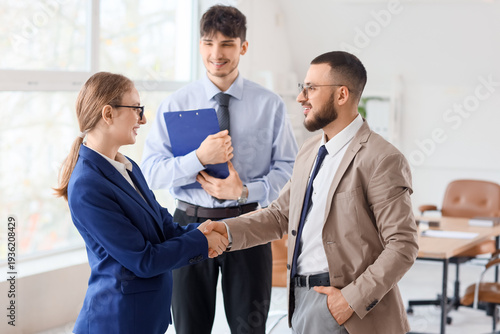 Business mediator and clients shaking hands in office