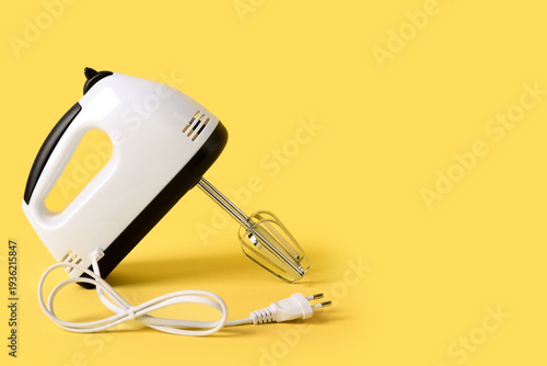 Electric mixer on yellow ba...