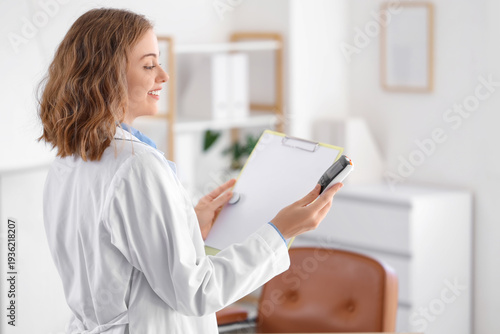 Female doctor with glucometer and glucose sensor in office