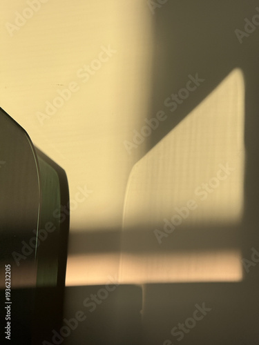 A shadow of a guitar is cast on a wall
