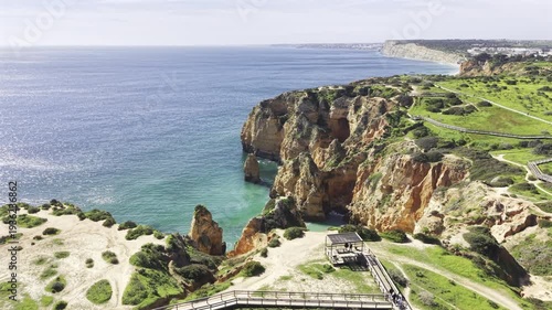 Lagos, Portugal HDR drone video - Aerial view of Algarve coast near Ponta da Piedade with boardwalk trails along the cliffs overlooking the secluded beaches below.
