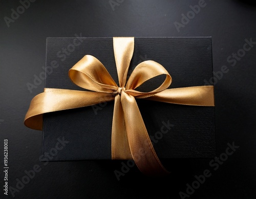 elegant black gift box with a shiny gold ribbon bow perfect for celebrations occasions and special events