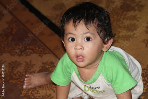 Close-up of a cute toddler boy with a funny surprised facial expression. Candid moment of childhood curiosity and wonder. Great for parenting blogs, baby products, and emotional storytelling in market