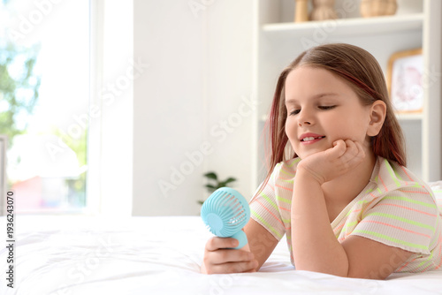 Cute girl with mini fan lyi...