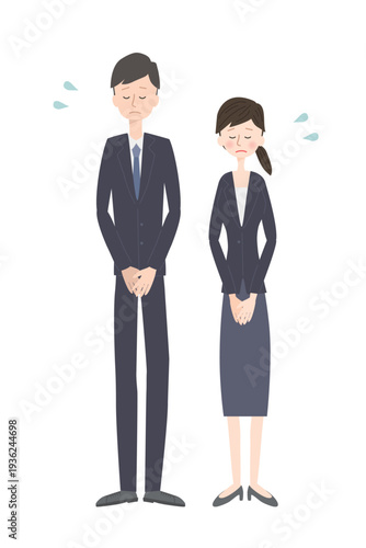 謝っているスーツ姿の男女