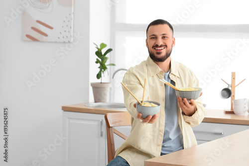 Young man with tasty ramen ...