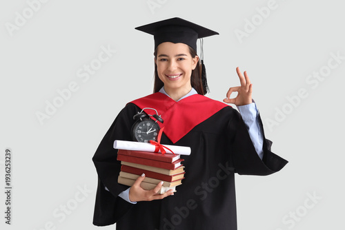 Female graduate with books ...