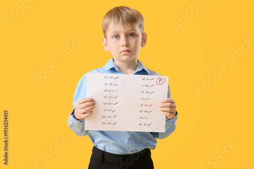 Sad schoolboy holding paper...