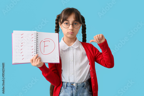 Happy schoolgirl holding no...