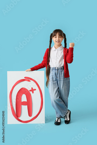 Happy schoolgirl holding po...