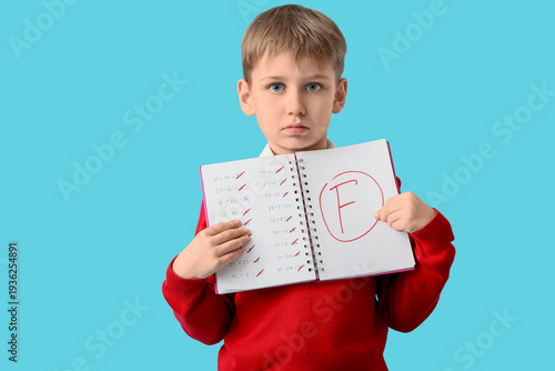Sad schoolboy holding noteb...