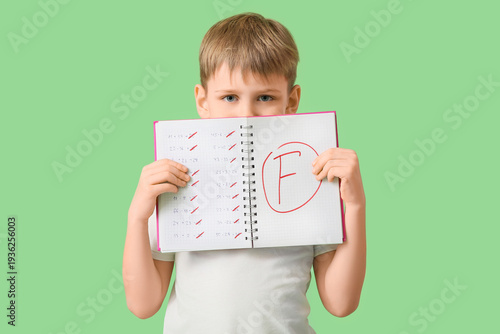 Sad schoolboy holding noteb...