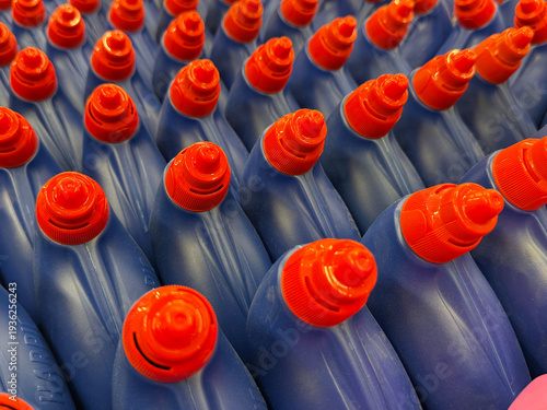 A row of blue bottles with red tops that say Harpic