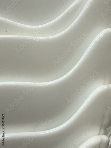 The image is a close up of a white toilet seat with a patterned design