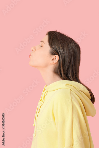 Young woman kissing on pink...